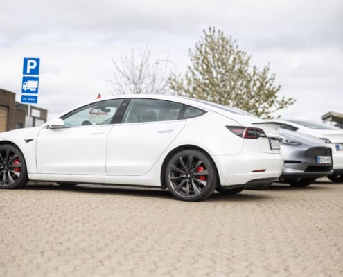 Hvid Tesla model 3 på parkeringspladsen