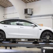 Tesla model 3 på lift på værkstedet
