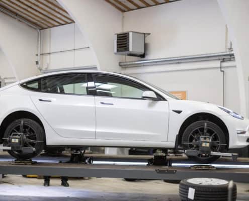 Tesla model 3 på lift på værkstedet