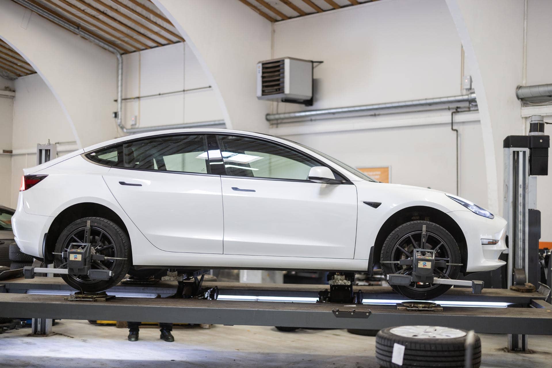 Tesla model 3 på lift på værkstedet