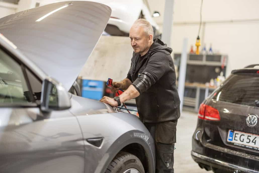 Certificeret mekaniker udfører reparation på Tesla Model S