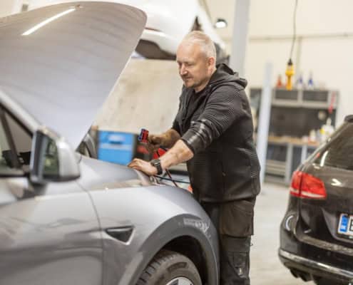 Certificeret mekaniker udfører reparation på Tesla Model S