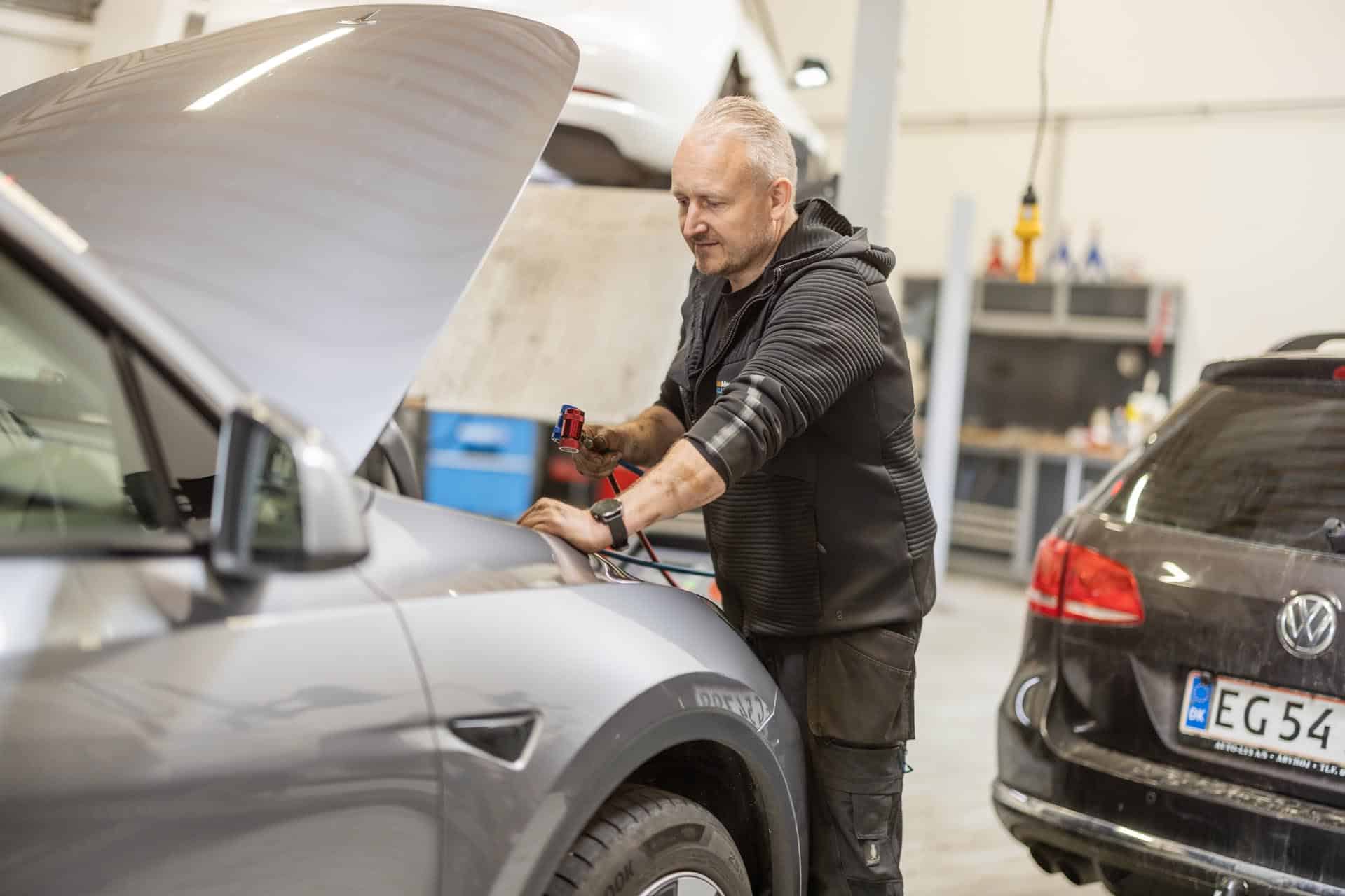 Certificeret mekaniker udfører reparation på Tesla Model S